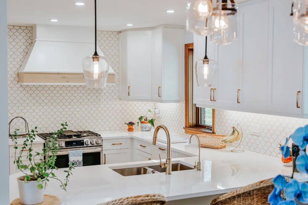 Bright, modern kitchen with white cabinets with brass hardware